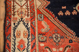 The ivory Serbend border and navy spandrel on a vintage hand-knotted Malayer rug corner.