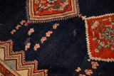 Close-up of a vintage Malayer showing low pile on the navy field and a red spandrel corner.
