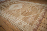 Angled view of a distressed Kars rug showing its heavily abrashed coffee and sand toned field.