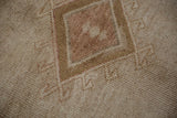 Detail of the low pile texture within the stepped medallion of a distressed vintage Kars rug.