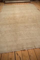 Distressed Kars carpet end, showing short, secured fringe and textured beige pile.