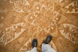 Time-softened short pile texture of a distressed Kars carpet in pale coffee and ivory tones.