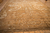Perspective view down the short pile of a distressed Kars carpet, showing floral motifs in sand and pale coffee brown.