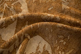 The short, nubby pile of a vintage distressed Kars carpet in shades of brown and ivory.