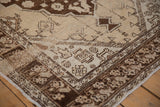 Vintage distressed Oushak rug corner, showing cream spandrel, chocolate brown tulip border, and heavy abrashes.