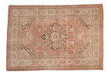 Distressed vintage Oushak carpet with a central floral medallion in dusty rose, brown, and ivory tones.