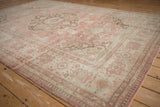 Angled view of the distressed Oushak carpet's scalloped medallion and stylized floral borders.