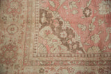 Floral corner spandrel and pawn motif border of a distressed vintage Oushak carpet.