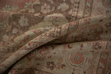 Detailed texture of a distressed Oushak carpet with a low pile in dusty rose and platinum.
