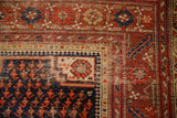 Hand-knotted antique Malayer rug corner, navy botehs, brick red geometric borders, and aged texture.