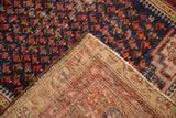 Antique Malayer rug close-up showing navy blue boteh pile, visible foundation, and intact selvage.