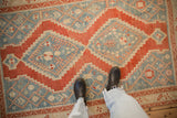 The soft, worn texture and stepped geometric medallion of a distressed vintage Karabagh rug.