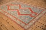 Diagonal view of a distressed Karabagh rug, highlighting the stepped cherry red medallion.