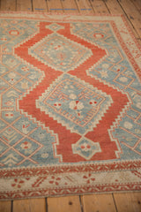 Perspective view of the distressed rug's stepped cherry red double medallions on a blue field.