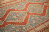 The distressed, low-pile texture of a Karabagh rug with cherry red stepped geometric motifs.