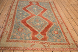 A vintage Karabagh rug's distressed texture and geometric design shown from a high angle.