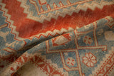 A soft fold on the vintage rug highlights its low, even pile and stepped medallion.