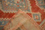Folded corner of a vintage Karabagh rug revealing its woven back and low, textured pile.