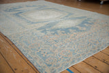 Angled perspective of a vintage distressed rug highlighting its soft blue and ivory colors.