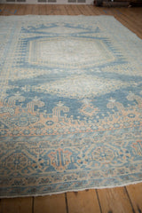 Low-angle view showing the time-softened pile and color variations of a distressed Persian rug.