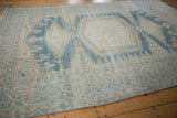 Decorative wear and abrash on the meandering vine border of a vintage Persian rug.
