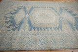 Angled perspective of a distressed Veece carpet, highlighting its worn texture and medallion design.
