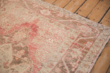 Faded coral and neutral beige floral motifs on a distressed vintage Oushak rug texture.