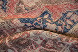 Distressed vintage Oushak rug with worn pile, revealing cobalt blue, ivory, and faded red patterns.