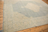 Distressed Tabriz rug corner, ivory palmette border and dusty denim blue abrashed field.