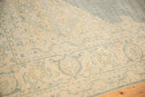 Vintage distressed Tabriz carpet detail, showing time-softened ivory and dusty blue floral motifs.