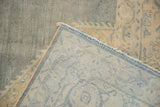 Reverse view of the vintage Tabriz rug, revealing tight hand knotting, soft blue fringe, and distressed pile.