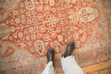 A top-down view highlighting the distressed texture and geometric relief of a vintage Bakhtiari rug.