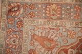 Close-up of the hand-knotted floral borders of a vintage distressed Persian Baktiari rug.