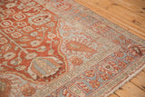 Angled view of a vintage Baktiari rug's low pile, highlighting the red field and geometric blue border.