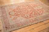 Angled perspective on a vintage distressed Baktiari rug showing the full geometric pattern.