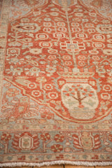 Close view of a distressed Baktiari rug's Tree of Life motif in cherry red and powder blue.