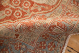 Close-up of the vintage Baktiari rug's hand-knotted texture and cherry red geometric relief pattern.
