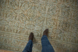 Distressed vintage Hamadan carpet displaying worn Herati pattern in soft tones.