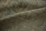 Distressed Hamadan carpet's low pile texture in soft ochre, sage, and dusty blue.