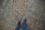 Mostly even wear across a vintage Tabriz carpet with floral vines in dusty blue and brown.