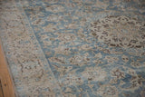 Time-softened pile of a distressed Tabriz showing floral arabesques in dusty blue and ivory.