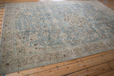 Angled perspective of a distressed Tabriz carpet showing the full sprawling floral pattern and even wear.