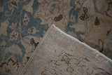 Corner view of a vintage Tabriz carpet showing the machine-bound edge and woven foundation.
