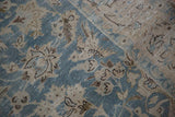 Detail of a scattered bird motif among florals on a distressed vintage Tabriz carpet.