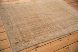 A distressed Persian Bijar rug showcasing its time-softened neutral Herati pattern.