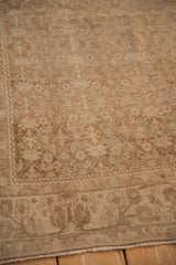 Evenly worn texture of a distressed Bijar rug's corner in sandy beige and pale brown.