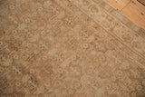 Angled view of a distressed vintage Bijar rug's corner showing the machine bound edge.