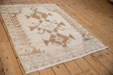 A vintage distressed Hamadan rug viewed from an angle, highlighting its low, even pile.