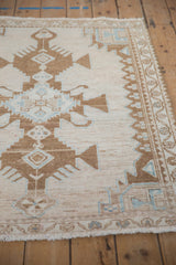 Side view of a vintage Hamadan rug showing the even wear and floral meandering vine border.