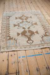 A vintage distressed Hamadan rug from a low angle, highlighting its even wear and serrated medallions.